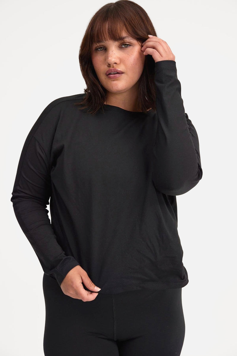 Woman in gray and black long sleeve shirt and black leggings