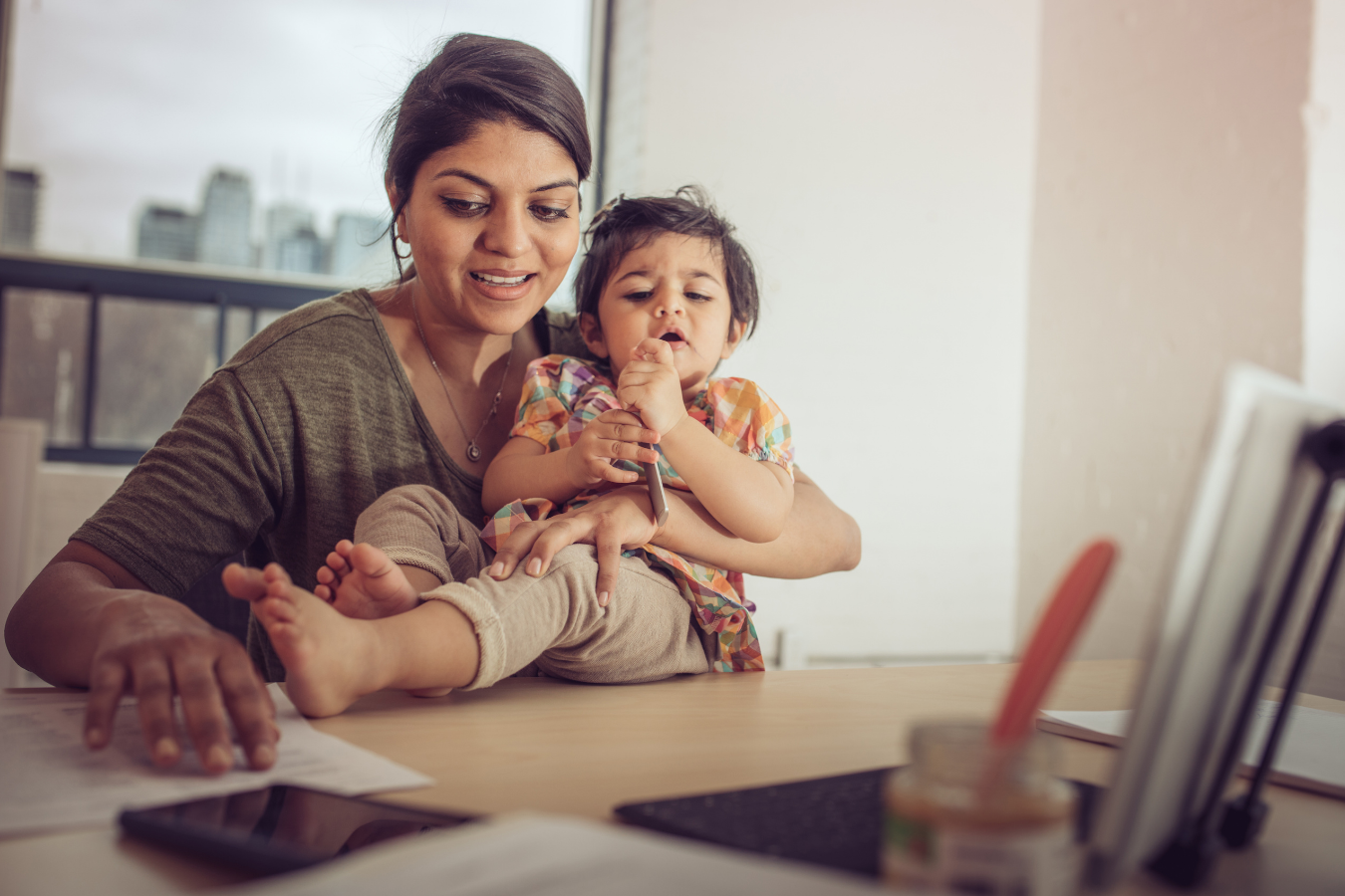 mother holding child on desk- US maternity leave compared to other countries- Mila's Keeper