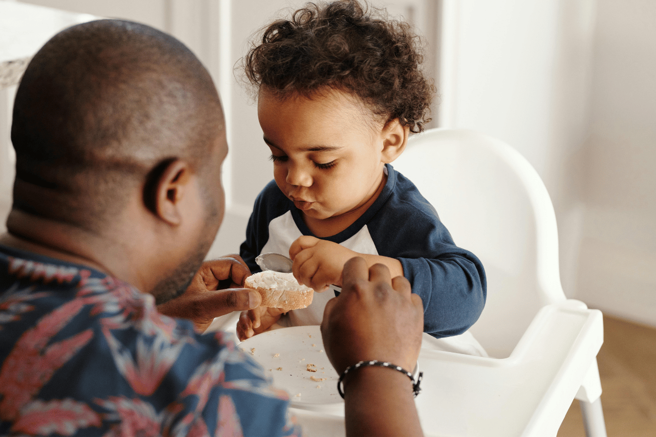 Dad feeding young child food-baby led weaning starter foods- Mila's Keeper