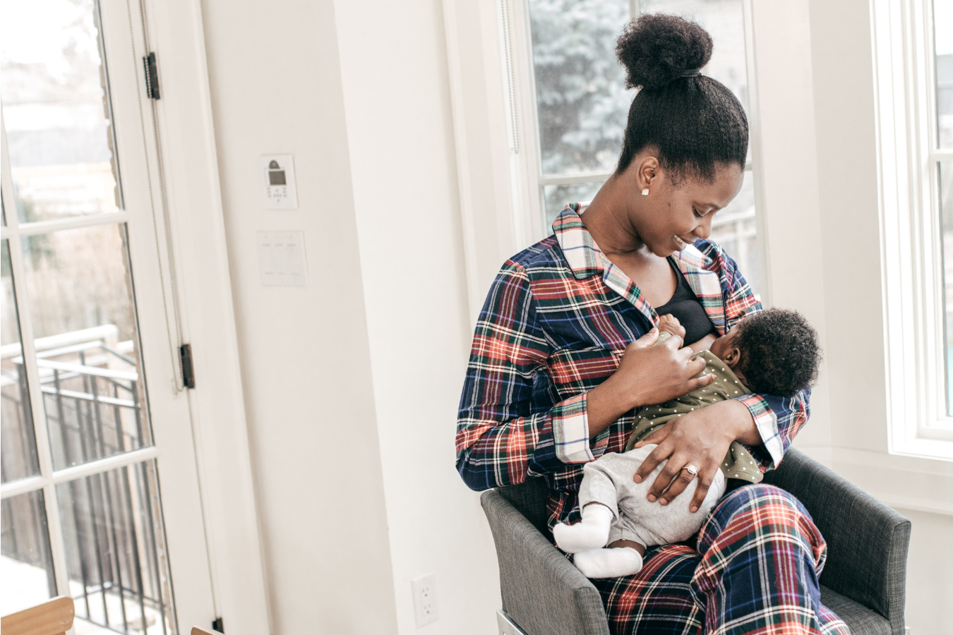 mom breastfeeds baby in chair-Origins of Breastfeeding in African Culture- Mila's Keeper