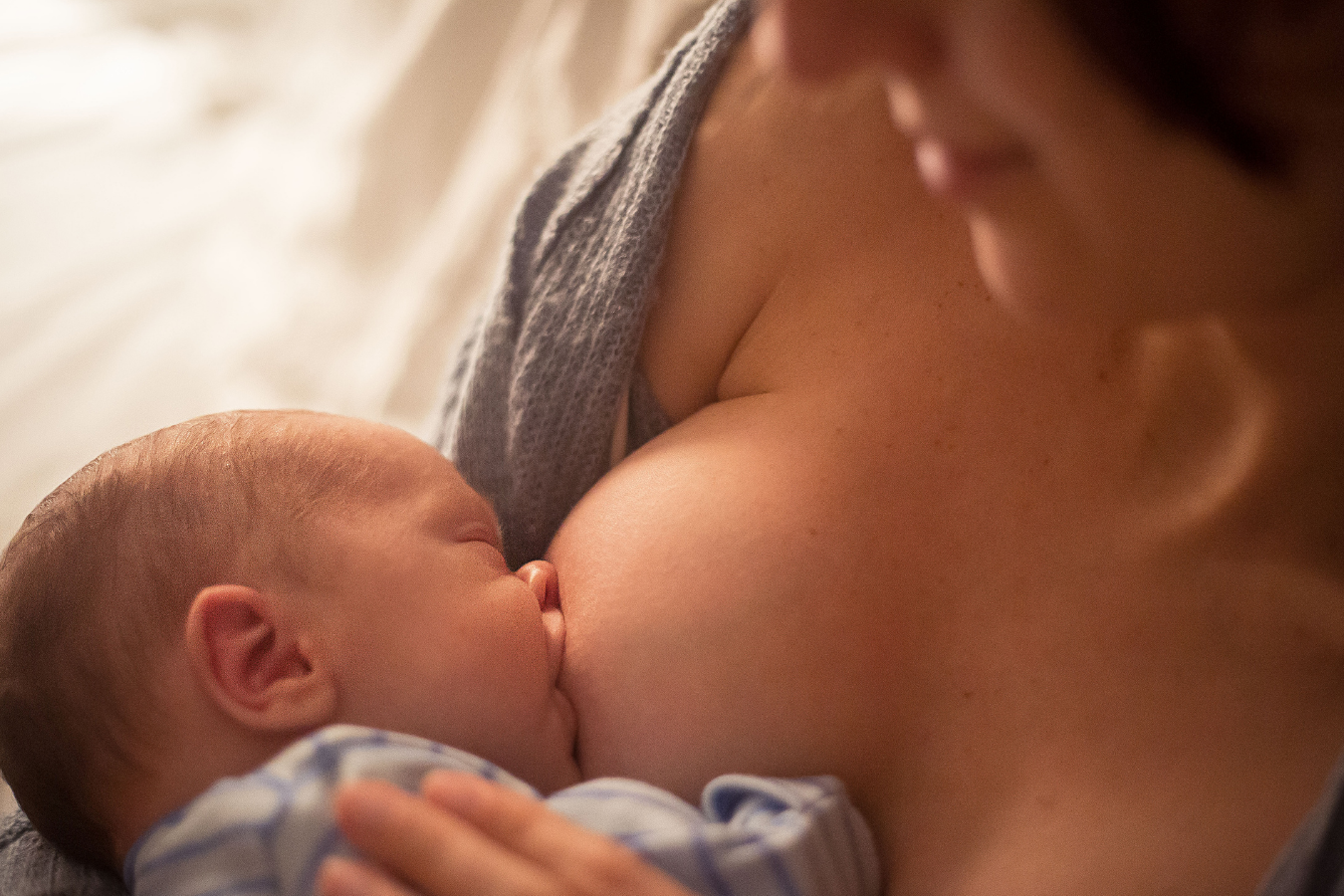 woman breastfeeding baby- Importance of Establishing a Breastfeeding and Pumping Schedule -Mila's Keeper