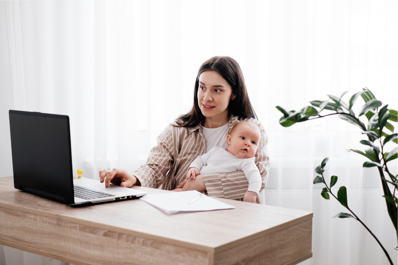 woman holding baby on computer-breastfeeding laws at work-Mia's Keeper
