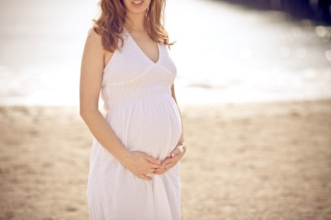 Pregnant woman on beach - HSA eligible blog