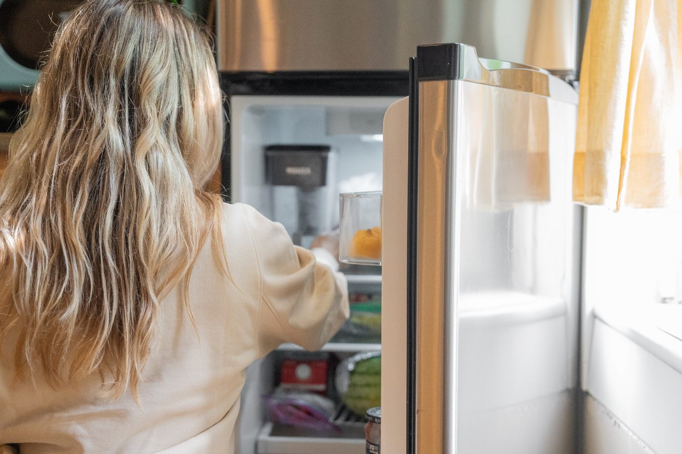 woman at fridge-can warmed breast milk be refrigerated again- Mila's Keeper