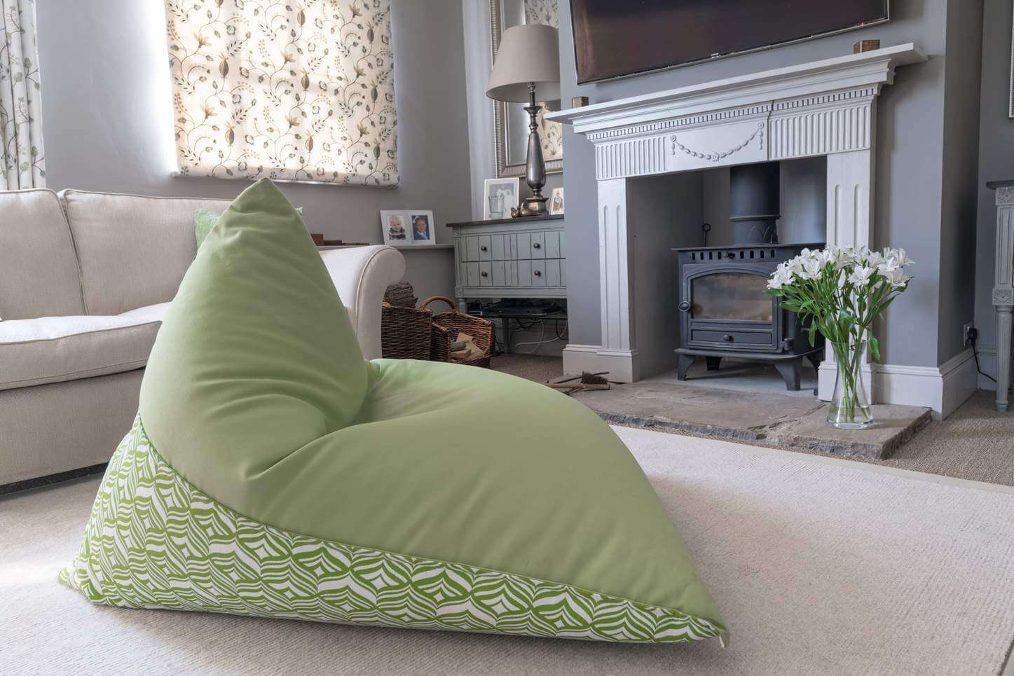 Lime green bean bag chair looking comfy in front of a fireplace