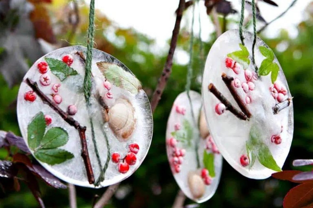 Outdoor decorations hanging from a tree made from ice and twigs and berries