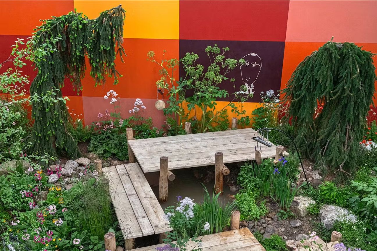 The Teapot Trust Eslewhere Garden from RHS Chelsea 2023 with bold brightly coloured squares of orange and red painted on the surrounding wall