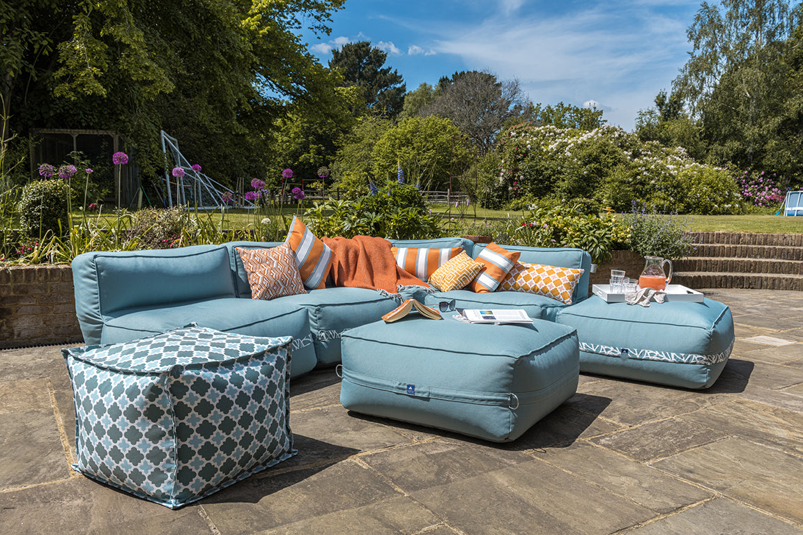 Garden sofa and ottoman on a perfectly positioned patio to catch the sun