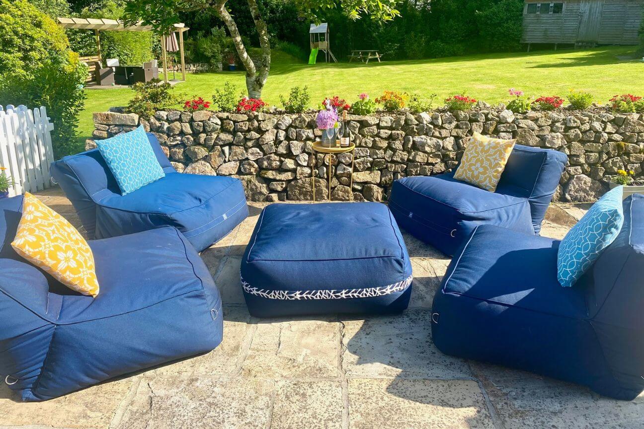 Bespoke navy blue garden sofa chairs and ottoman on a sunny patio