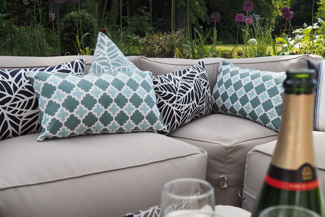 Soft fabric garden sofa outside and covered in cushions