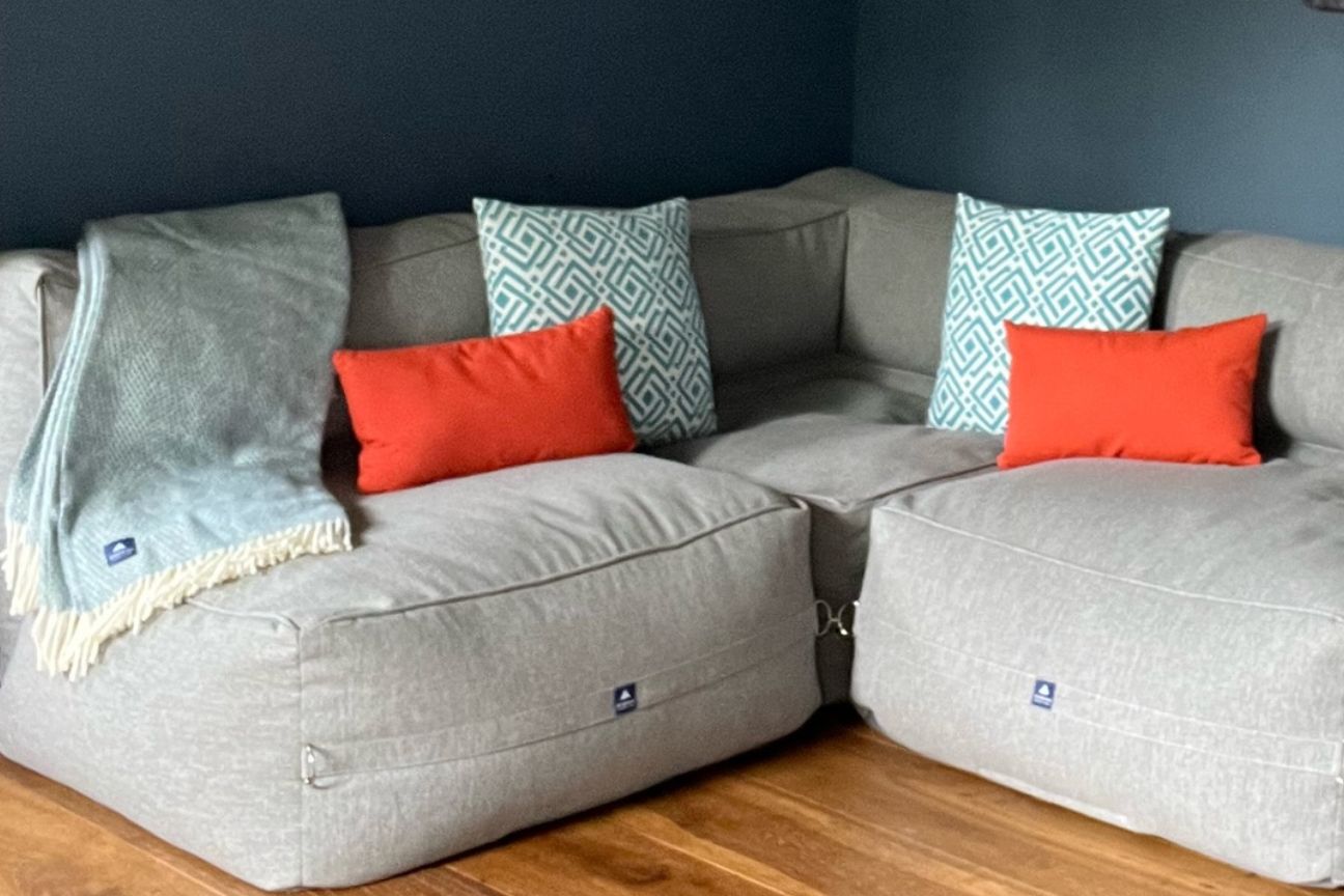 Paprika orange sofa cushions and blue and white geometric patterned sofa cushions on a light grey easy access sofa