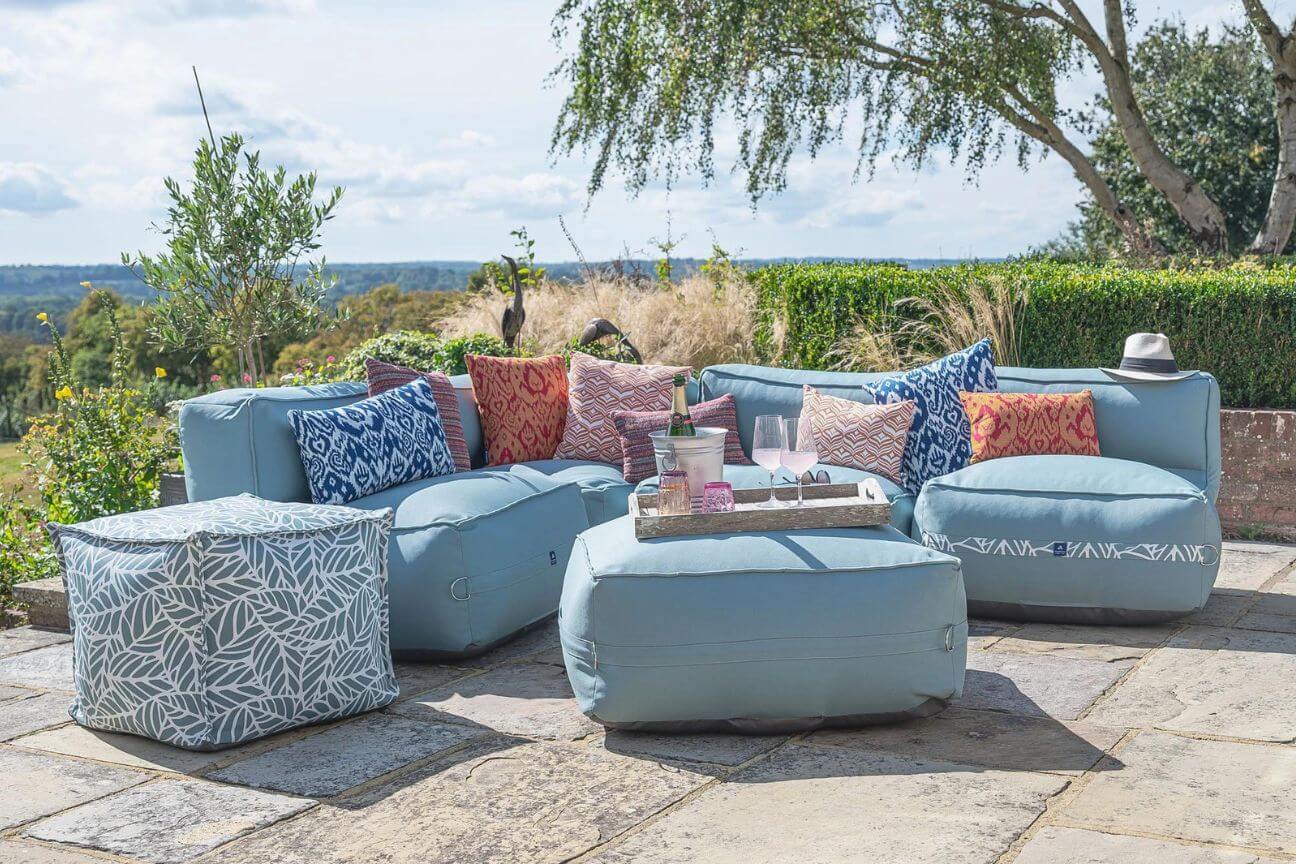 A stylish outdoor sofa in stain resistant fabric on a sunny patio