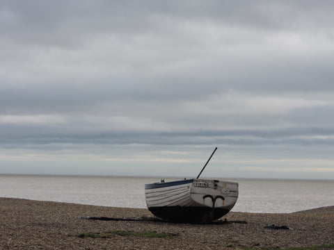 Boat on Aldeburgh beach with pebbles in the foreground and a dreamy sky in the background 