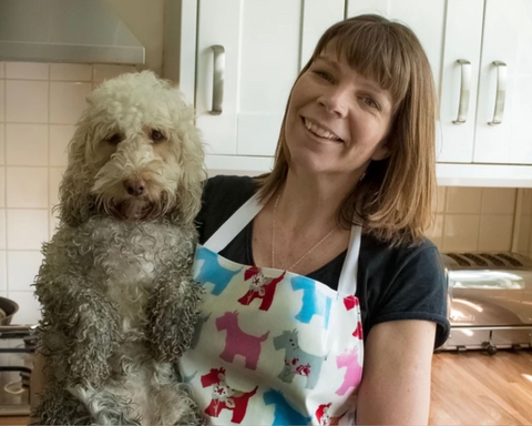 Woman wearing a wipe clean apron with her muddy cockerpoo