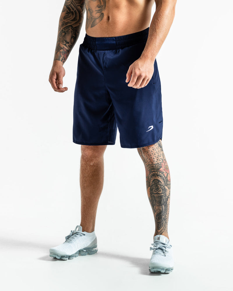 Man in navy training shorts with adjustable waistband and side zipped pockets as well as an embroidered white strike logo.