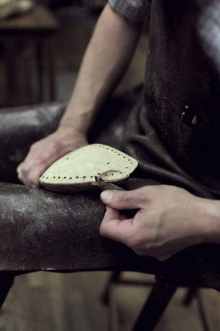 Workers crafting sandals using traditional techniques - Touchy Style