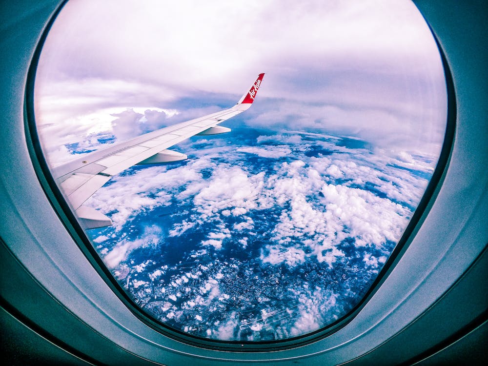 Clouds and airplane wing from plane window