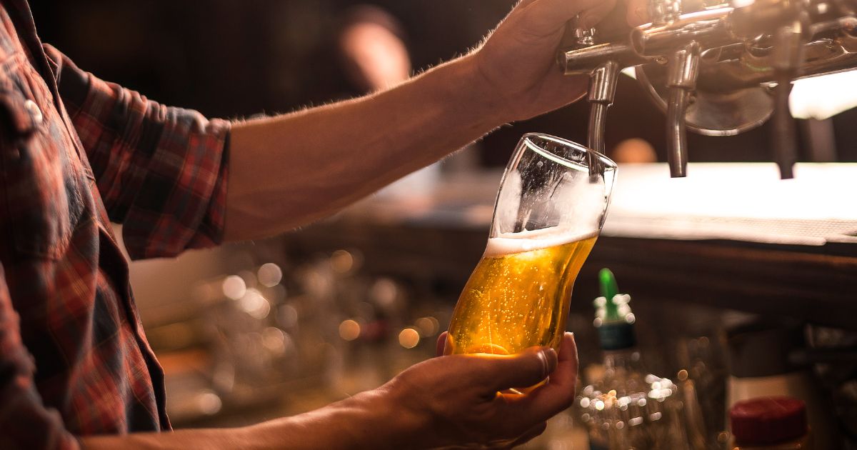 A man pouring a beer from draught