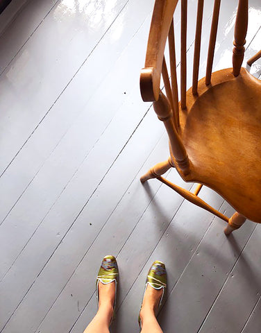 view from above of green and pink silk loafers and wooden chair. 