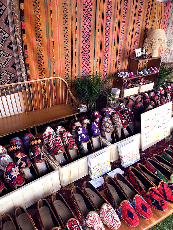 mens kilim loafers displayed with womens kilim loafers surrounded by kilim carpets.