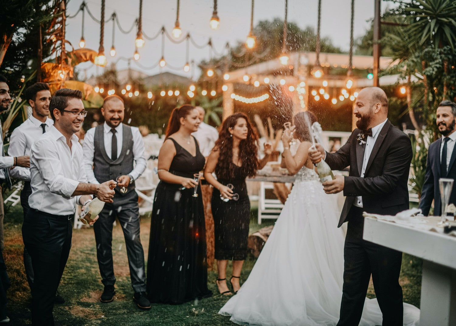 Wedding attendees popping champagne