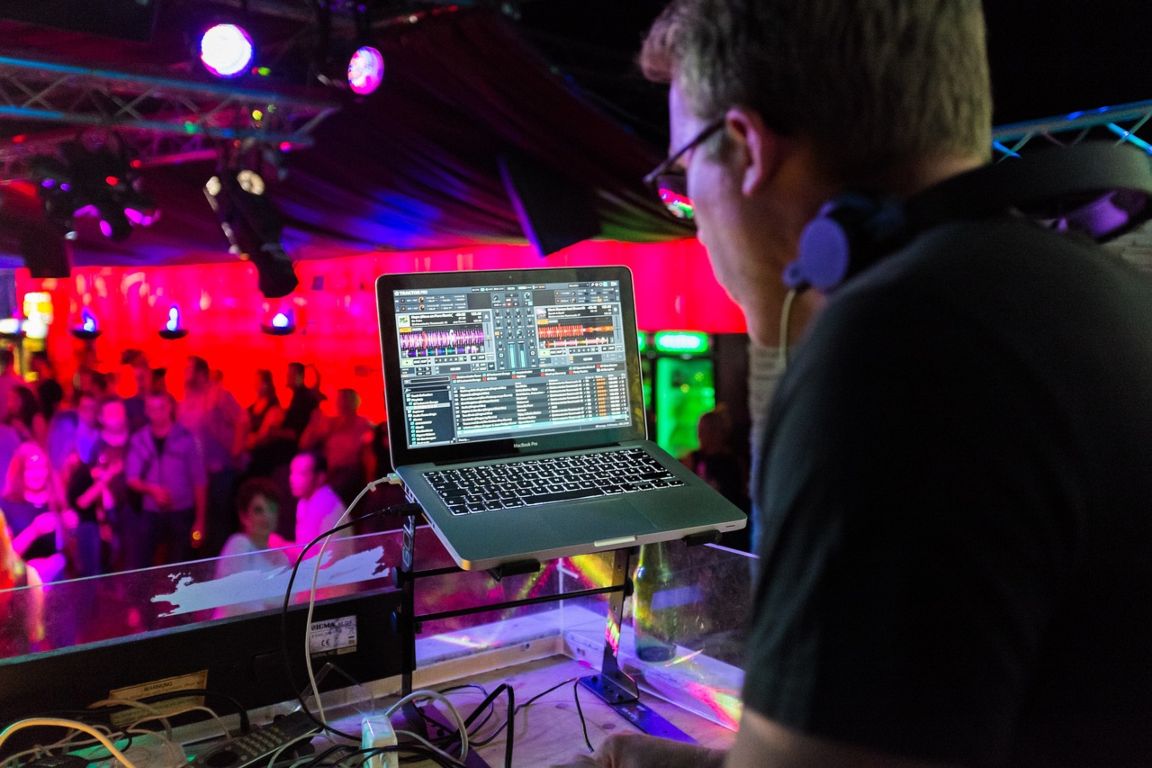 Man using DJ software on laptop
