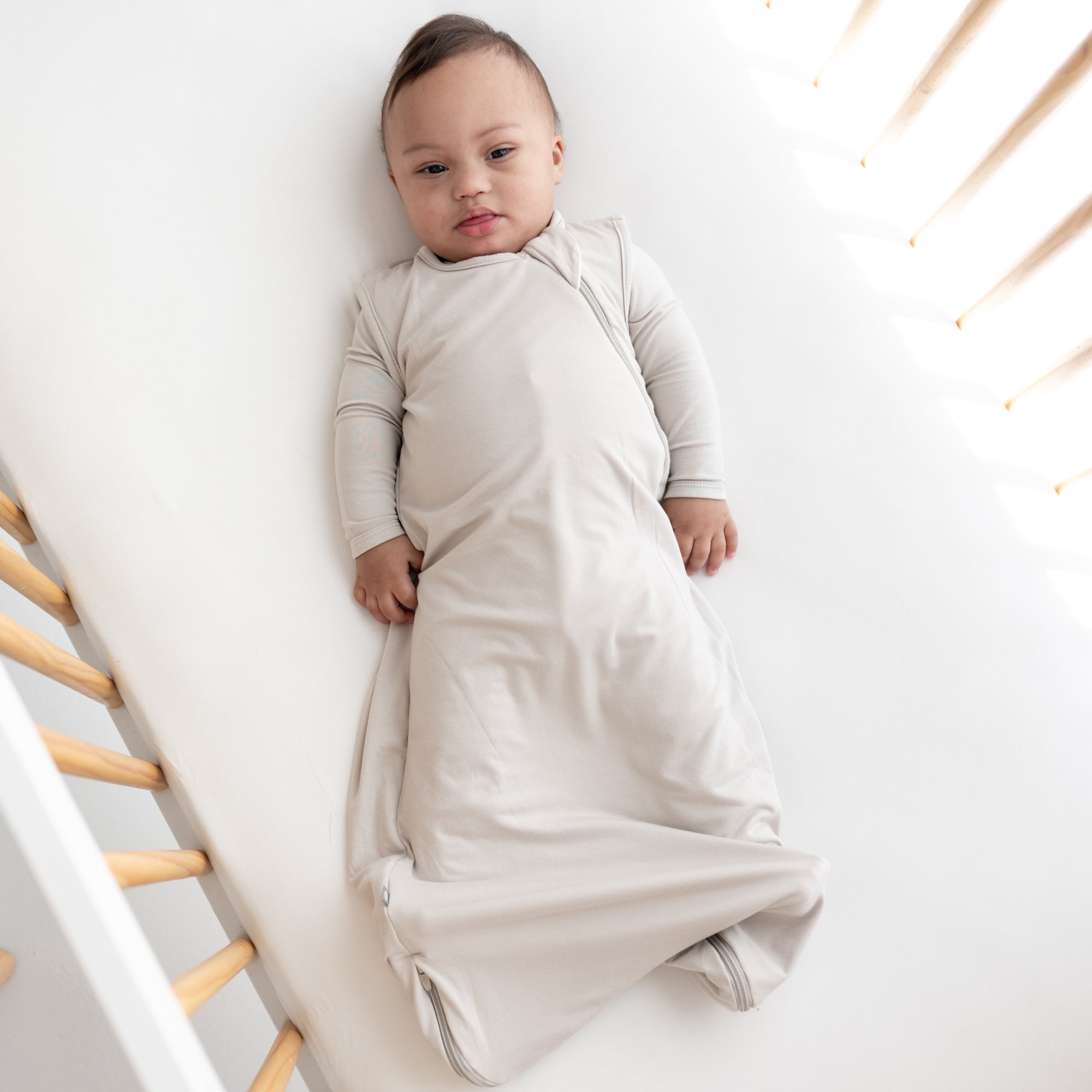 Baby awake laying down in their crib staring at the camera