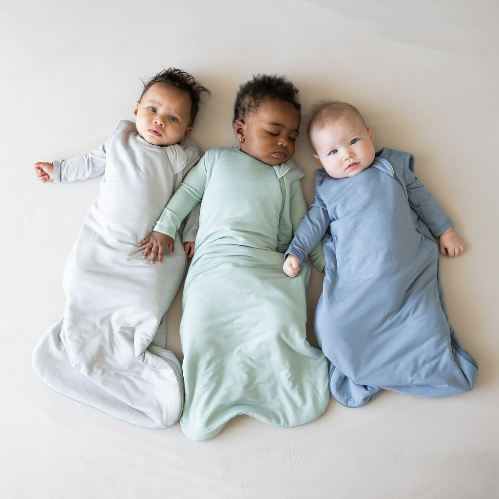 Three babies laying peacefully in buttery soft bamboo sleep bags 