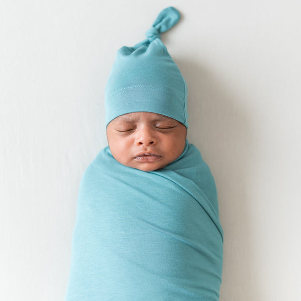 Sleeping newborn wearing kyte baby knotted cap