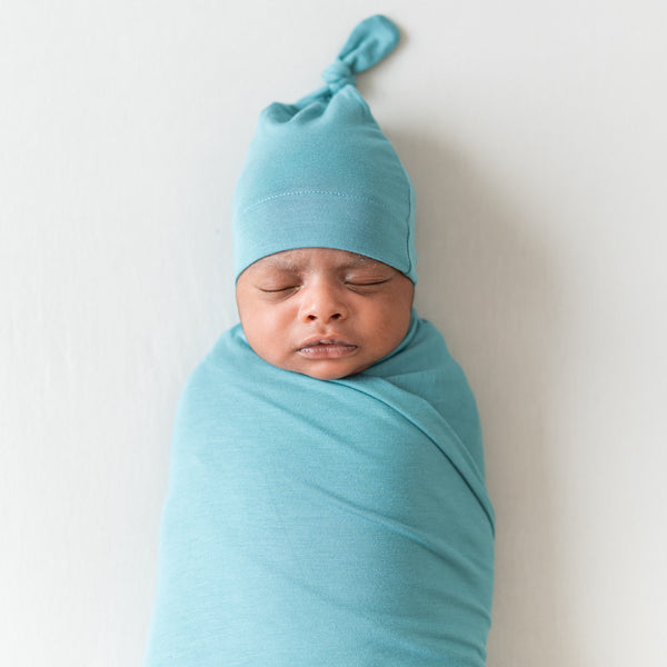 Sleeping newborn wearing kyte baby knotted cap 