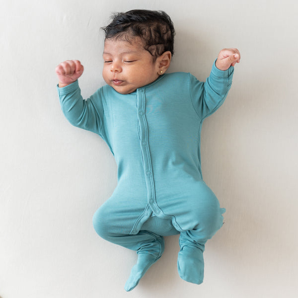 Newborn baby sleeping in kyte baby footie