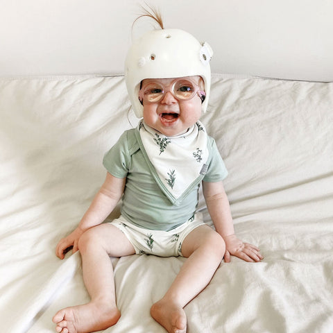 baby wearing a kyte baby bib in eucalyptus print
