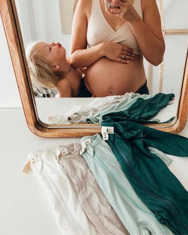 reflection of pregnant mom and toddler in mirror