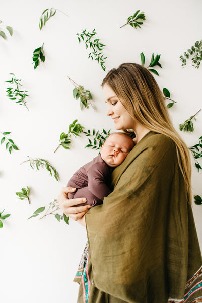 mom holding newborn baby against chest