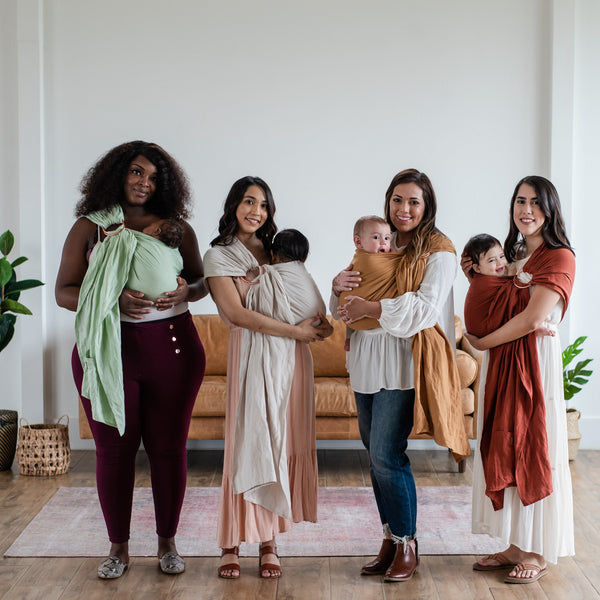 four women wearing their babies in kyte baby ring slings