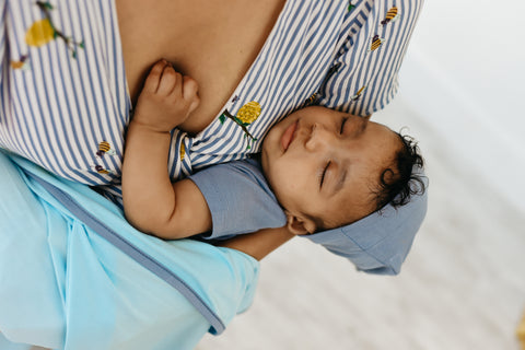 baby sleeping in mother's arms