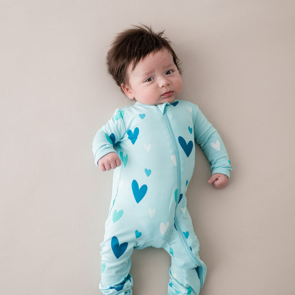 baby wearing kyte baby romper in robin hearts print