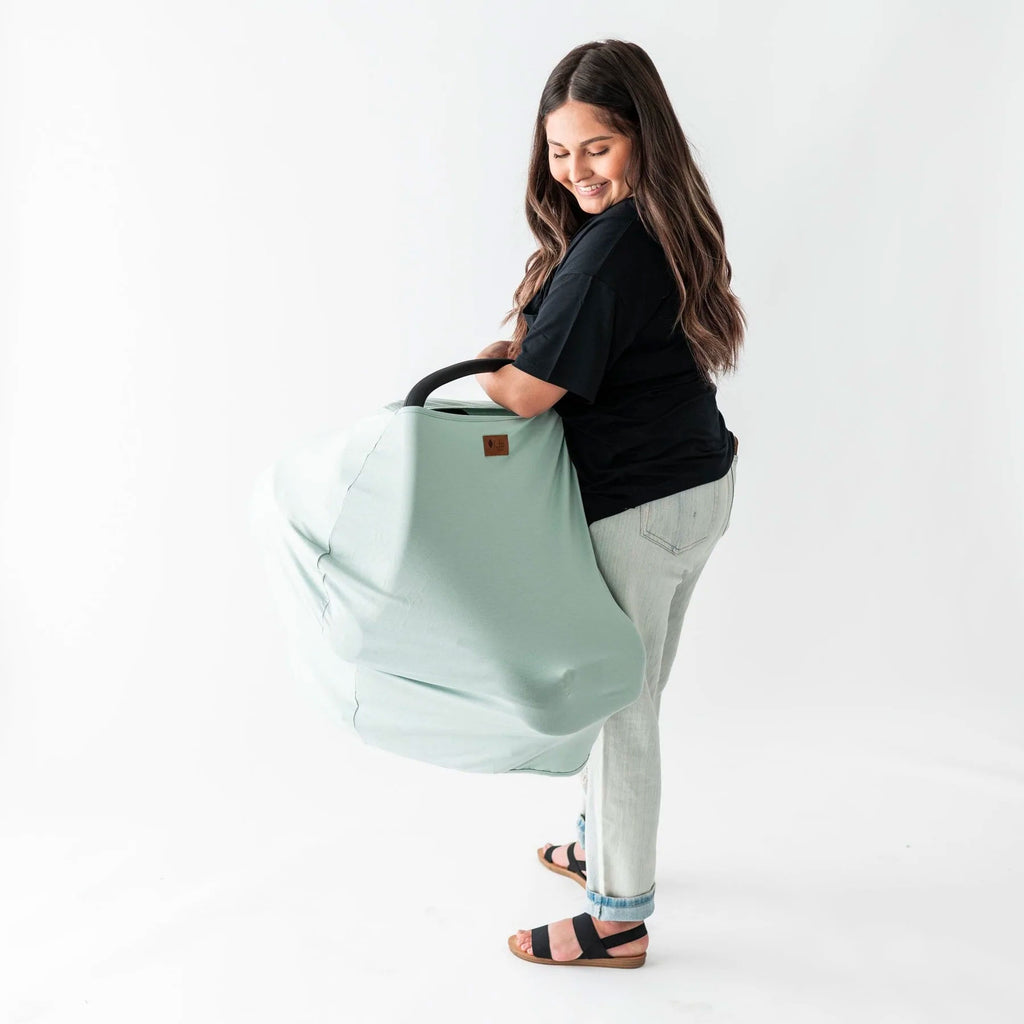 mom holding a car seat with a kyte baby car seat cover