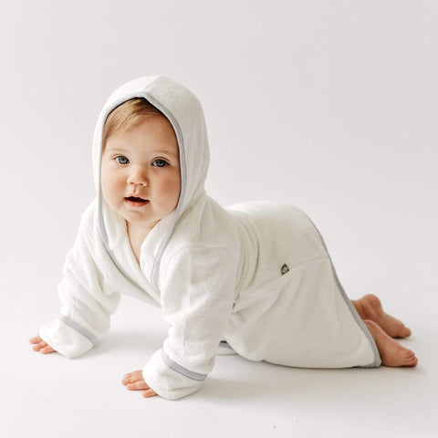 baby crawling on the floor wearing kyte baby toddler bathrobe