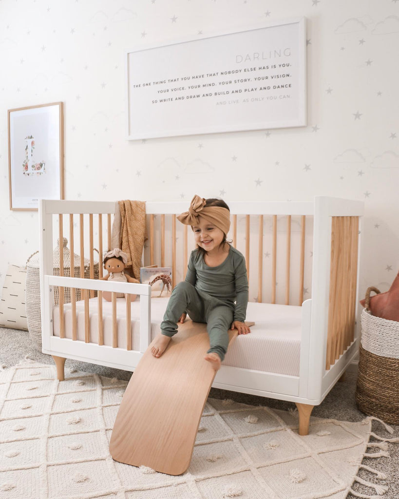 girl sliding down toddler bed slide with pjs on