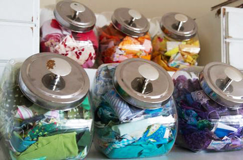 Penny candy jars field with fabric scraps.