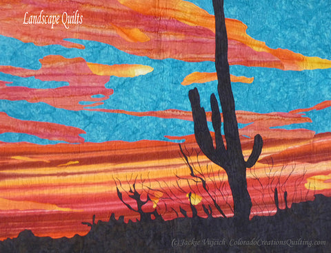 A landscape quilt featuring a silhouette of a lone saguaro cactus with a vibrant blue and orange sunset in the background by Colorado Creations Quilting