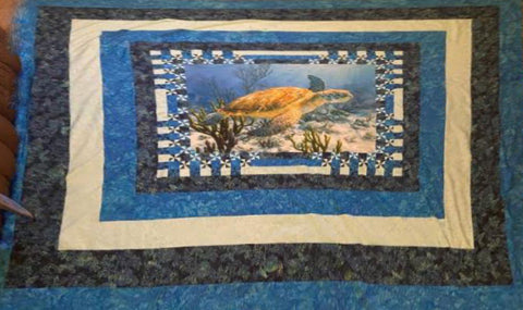 Quilt featuring a sea turtle in the center.