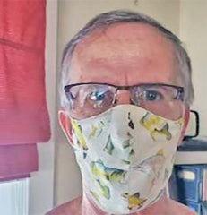 Marth G.'s husband wearing a face mask made of quilting cotton featuring fish that she got from Colorado Creations Quilting