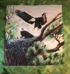 Quilt with eagles in a nest surrounded by a green border.