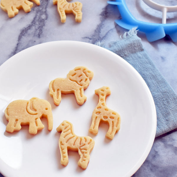 baked animal cookies on plate with SideSwipe flex edge beater for KitchenAid in background, including elephant, giraffe, lion and zebra