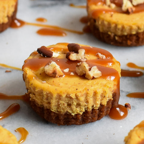 mini pumpkin cheesecake close, drizzled with chopped pecans and caramel