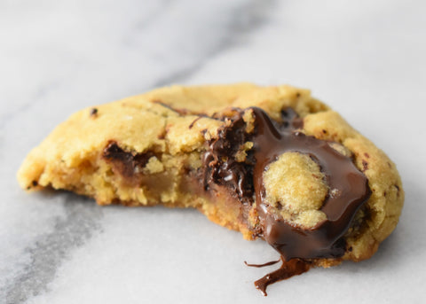 olive oil chocolate chunk cookie with bite taken and gooey chocolate