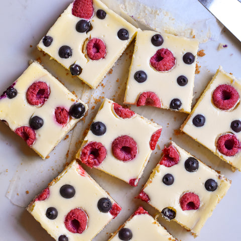 cheesecake bar slices studded with raspberries and blueberries overhead