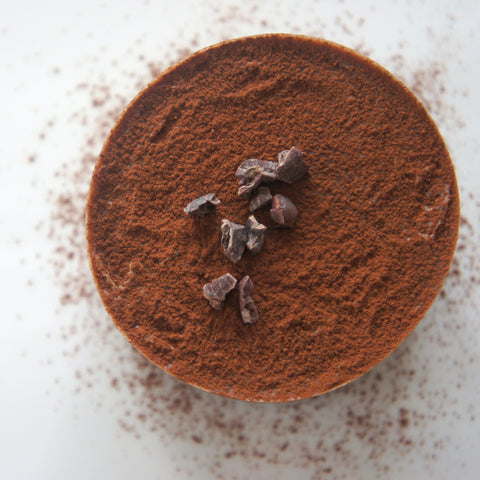 cocoa powder in a bowl, topped with cocoa nibs